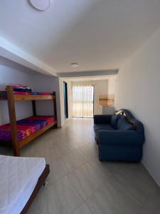 een slaapkamer met een bed en een blauwe bank in een kamer bij Finca Descanso Fronterita Sanjeronimo in San Jerónimo