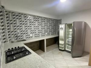 een keuken met een fornuis en een roestvrijstalen koelkast bij Finca Descanso Fronterita Sanjeronimo in San Jerónimo
