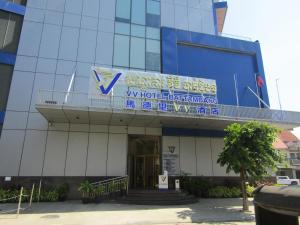 un edificio con un cartel en la parte delantera en V V Hotel Battambang en Battambang