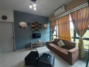 a living room with a couch and a tv at Jesselton Quay Rashzia Kota kinabalu in Kota Kinabalu
