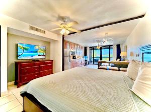 um quarto com uma cama, uma televisão e uma cozinha em Sapphire Beachfront Condo - View of Paradise - Free Wi - Fi C-7 em East End