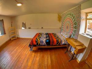 1 dormitorio con 1 cama y suelo de madera en Tayta Wasi Rent Pisac en Pisac