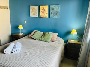 a blue bedroom with a bed with towels on it at Hermoso departamento barrio norte comodo amplio y luminoso in San Miguel de Tucumán