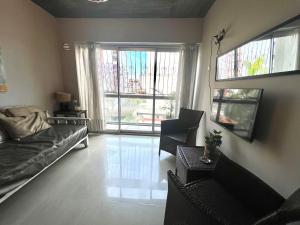 - un salon avec un canapé, des chaises et une fenêtre dans l'établissement Hermoso departamento barrio norte comodo amplio y luminoso, à San Miguel de Tucumán