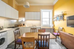 cocina con mesa de madera y sillas en 5-BR 3-BTH Newington Apartment - Modern & Spacious en Edimburgo