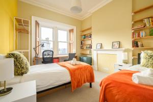 a bedroom with two beds and a fireplace at 5-BR 3-BTH Newington Apartment - Modern & Spacious in Edinburgh