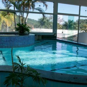 a large swimming pool with blue water and windows at Hotel Manoah in Socorro