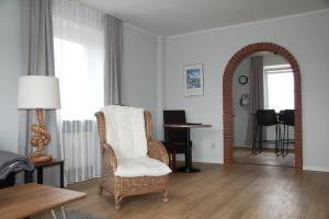 a living room with a chair and an archway at Ferienwohnung Tidenblick in Wittdün