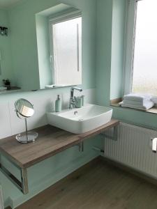 a bathroom with a white sink and a mirror at Ferienwohnung Tidenblick in Wittdün