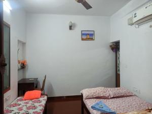Habitación con cama, mesa y espejo. en Angels' homestay Marari, en Mararikulam
