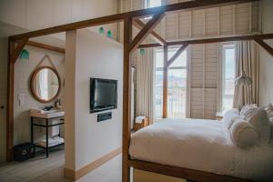 sypialnia z łóżkiem, telewizorem i umywalką w obiekcie Hôtel & Spa Le Germain Charlevoix w mieście Baie-Saint-Paul
