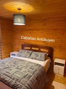 1 dormitorio con 1 cama en una habitación de madera en CABAÑAS ANTU KUYEN, en Pichilemu