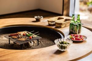 einen Tisch mit Speisen und Flaschen Bier und einen Tisch mit Getränken in der Unterkunft Uwanosora Bed&BBQ&Sauna in Shizuoka