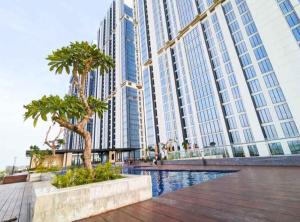 a large building with palm trees in front of it at Apartement Studio Pollux Habibi Batam A13715 HOT PROMOTION WITHOUT WIFI in Batam Center