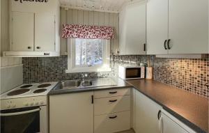 a kitchen with white cabinets and a sink and a window at Gorgeous Home In Trysil With House A Mountain View in Trysil