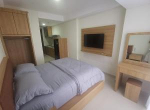 1 dormitorio con 1 cama y TV en Apartement Studio Pollux Habibi Batam A13712, en Batam Centre