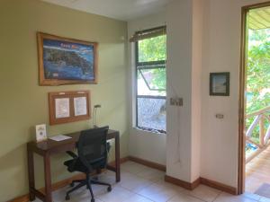 ein Büro mit einem Schreibtisch, einem Stuhl und einem Fenster in der Unterkunft Villas Solar in Playa Santa Teresa