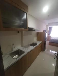 a kitchen with a sink and a counter top at Apartement Studio Pollux Habibi Batam A13712 in Batam Center