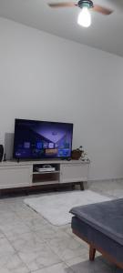 sala de estar con TV de pantalla plana en un centro de entretenimiento en Casa próxima ao centro! en Uberaba