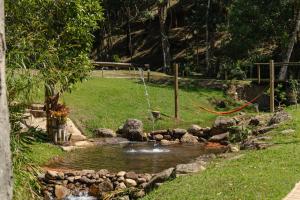 a garden with a pond with a water fountain at Matha Pousada e Bistrô in Lumiar