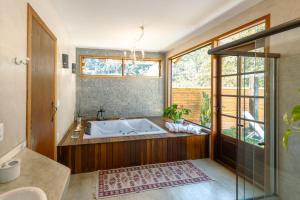 a large bathroom with a tub and a window at Matha Pousada e Bistrô in Lumiar