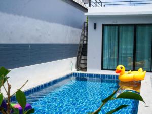 a rubber duck in a swimming pool next to a house at M View Pool villa in Cha Am