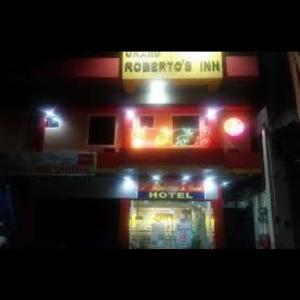 une station-service avec des lumières rouges et un hôtel dans l'établissement Grand robertos inn bangued abra, à Bangued