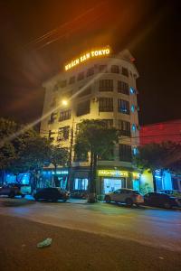 a tall building with cars parked in front of it at night at Khách San Tokyo in Lao Cai