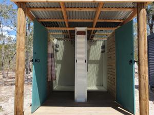 una puerta delantera de una casa con techo de madera en Eureka Station Camping Retreat, en Apple Tree Creek