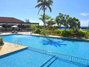 a large swimming pool with a palm tree in the middle at Hotel Breezebay Marina in Miyako Island