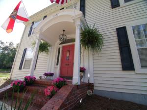 une maison avec une porte rouge et des fleurs sur les marches. dans l'établissement The Capitol Inn, à Tallahassee