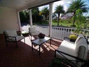 - une terrasse couverte avec 2 chaises, un canapé et une table dans l'établissement The Capitol Inn, à Tallahassee