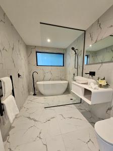 a white bathroom with a tub and a sink at Elia's House in Queenstown