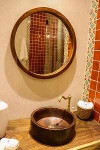 a bathroom with a sink with a large mirror at Hotel Boutique Gloriagave in Tequila