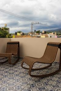 Hotel Boutique Gloriagave في تيكيلا: كرسيان الخوص يجلسون فوق الشرفة