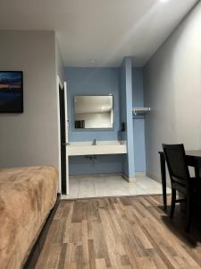 a bedroom with a bed and a table and a mirror at Moonlite Inn in Redondo Beach