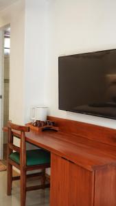 a wooden desk with a television on a wall at Senare Boracay Hotel in Boracay