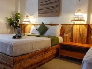 um quarto com uma cama de madeira e 2 candeeiros em Senare Boracay Hotel em Boracay