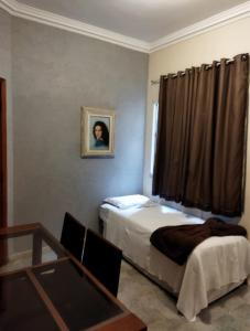 a room with two beds and a table and a picture at Ipanema Vinicius de Moraes in Rio de Janeiro