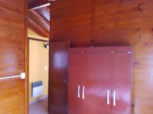 una gran puerta marrón en una habitación con paredes de madera en CABAÑA LOS SAUCES en San Clemente del Tuyú