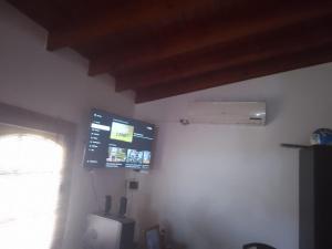 Habitación con ventana y TV en la pared. en CABAÑA LOS SAUCES en San Clemente del Tuyú