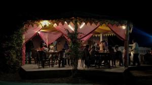 a group of people sitting at tables under a tent at Surkhab rann resort in Dhordo