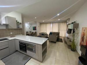 eine Küche und ein Wohnzimmer mit einem Sofa und einem Tisch in der Unterkunft Incredible 2 Bedroom Space Available in Accra