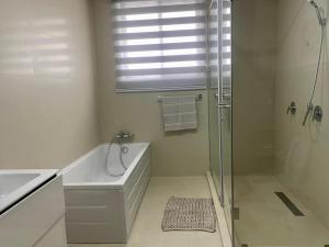 ein Bad mit einer Badewanne, einer Dusche und einem Waschbecken in der Unterkunft Incredible 2 Bedroom Space Available in Accra