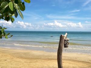a wooden pole on a beach with the ocean at Room in Bungalow - Family Cottage of Koh Pu in Ko Jum