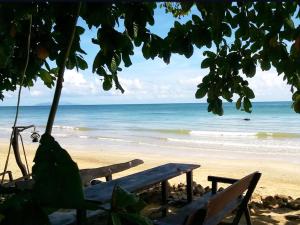a bench on a beach with a view of the ocean at Room in Bungalow - Family Cottage of Koh Pu in Ko Jum
