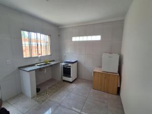 een kleine keuken met een wastafel en een koelkast bij Araçariguama in Araçariguama