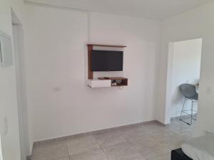 Habitación blanca con TV en la pared en Araçariguama en Araçariguama