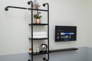 a black towel rack with towels on a wall at Hotel Luma Senawang in Seremban