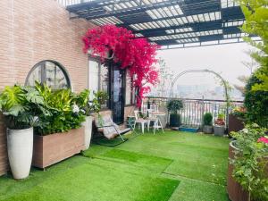 - un patio avec des plantes et des fleurs dans un bâtiment dans l'établissement N&D Happy House- Studio Apartment - Phong tieu chuan khach san, bep nau va nha ve sinh trong khuon vien, à Hanoï